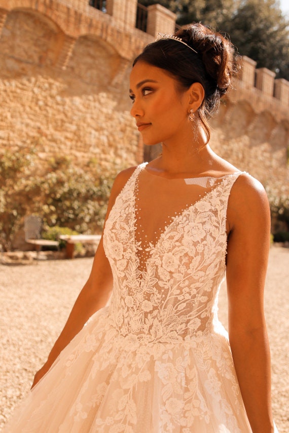 Elegant Lace and Tulle Ball Gown Wedding Dress with Deep V-Neckline and Intricate Floral Appliqués, Featuring a Sparkling Full Skirt