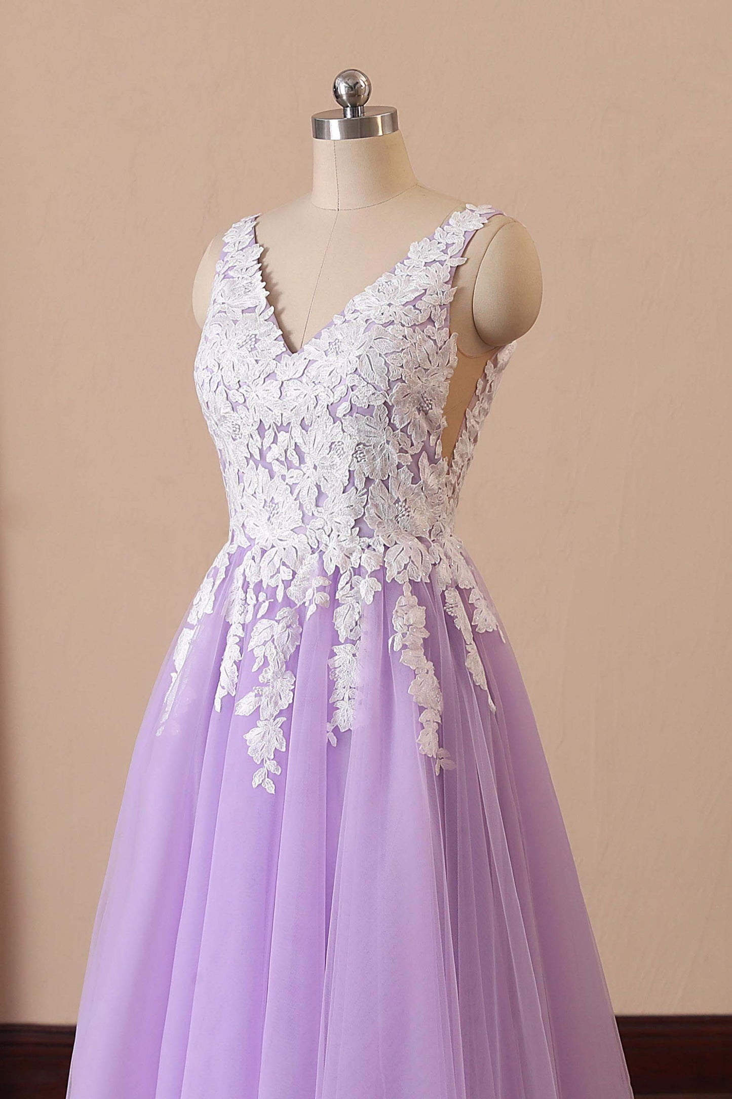 Close-up of lace appliqué on lilac bridal gown bodice