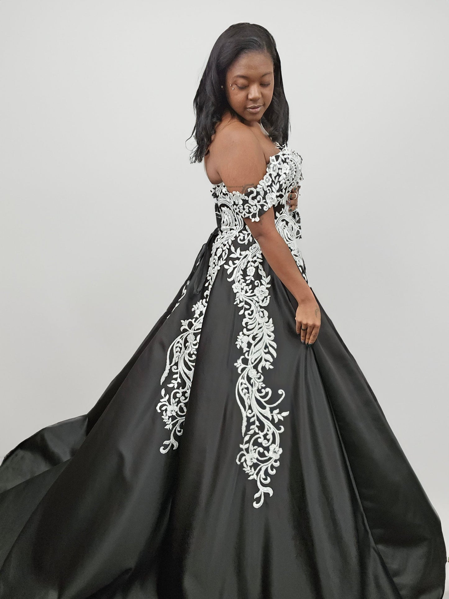 Side view of bride in off-shoulder black embroidered wedding dress