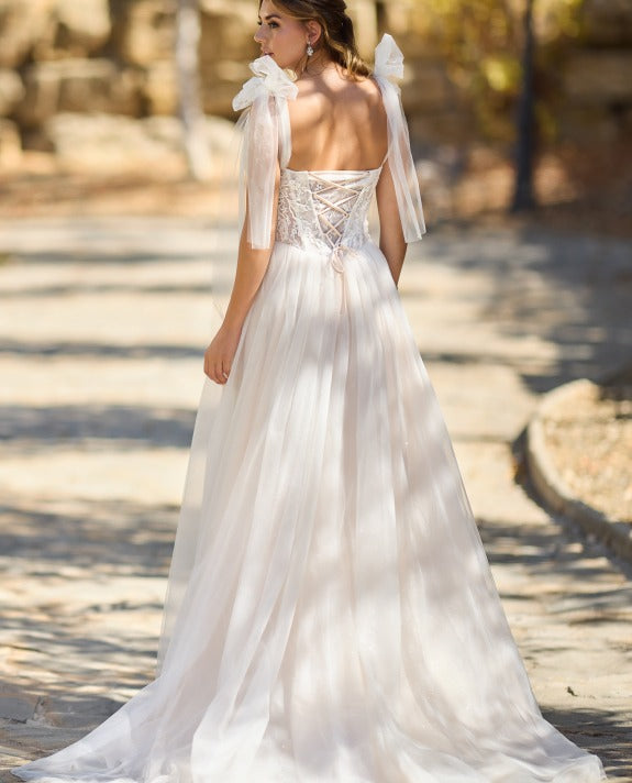 Eenika Très Chic wedding dress with lace-up corset back, statement tulle bow straps and flowing glitter tulle A-line skirt