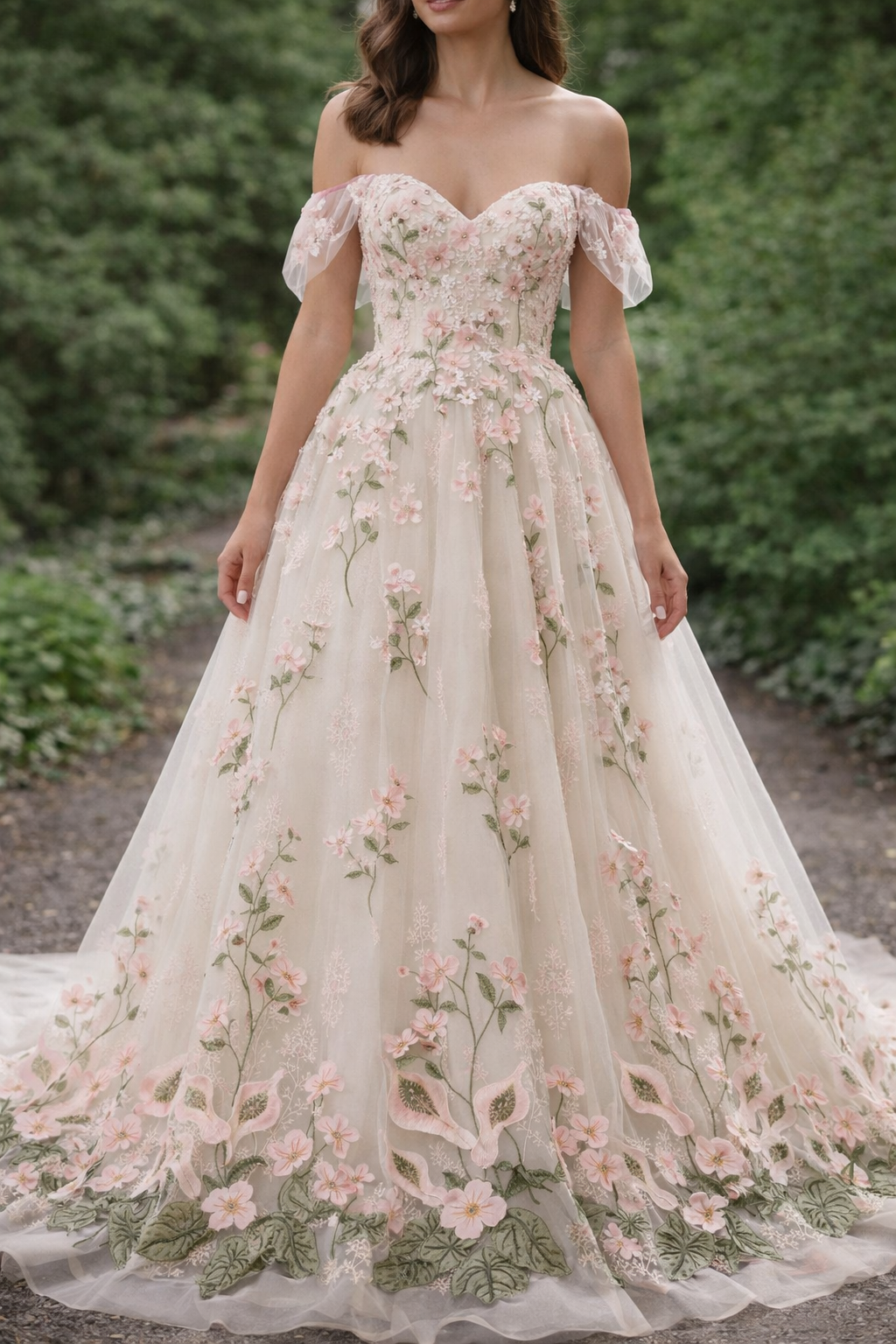 Angelique floral embroidered wedding dress with pink blossoms and off shoulder sleeves in a romantic garden setting