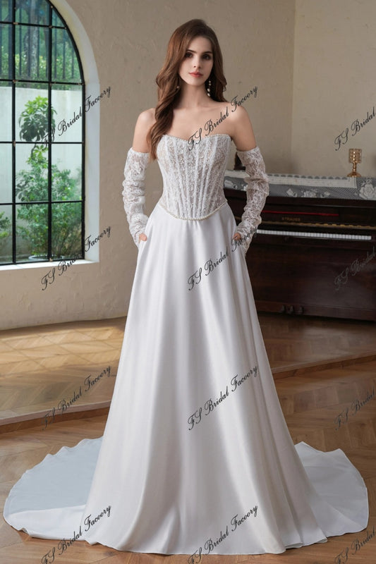 Front view of Eugénie off-shoulder lace corset wedding dress with long lace sleeves and satin A-line skirt with pockets