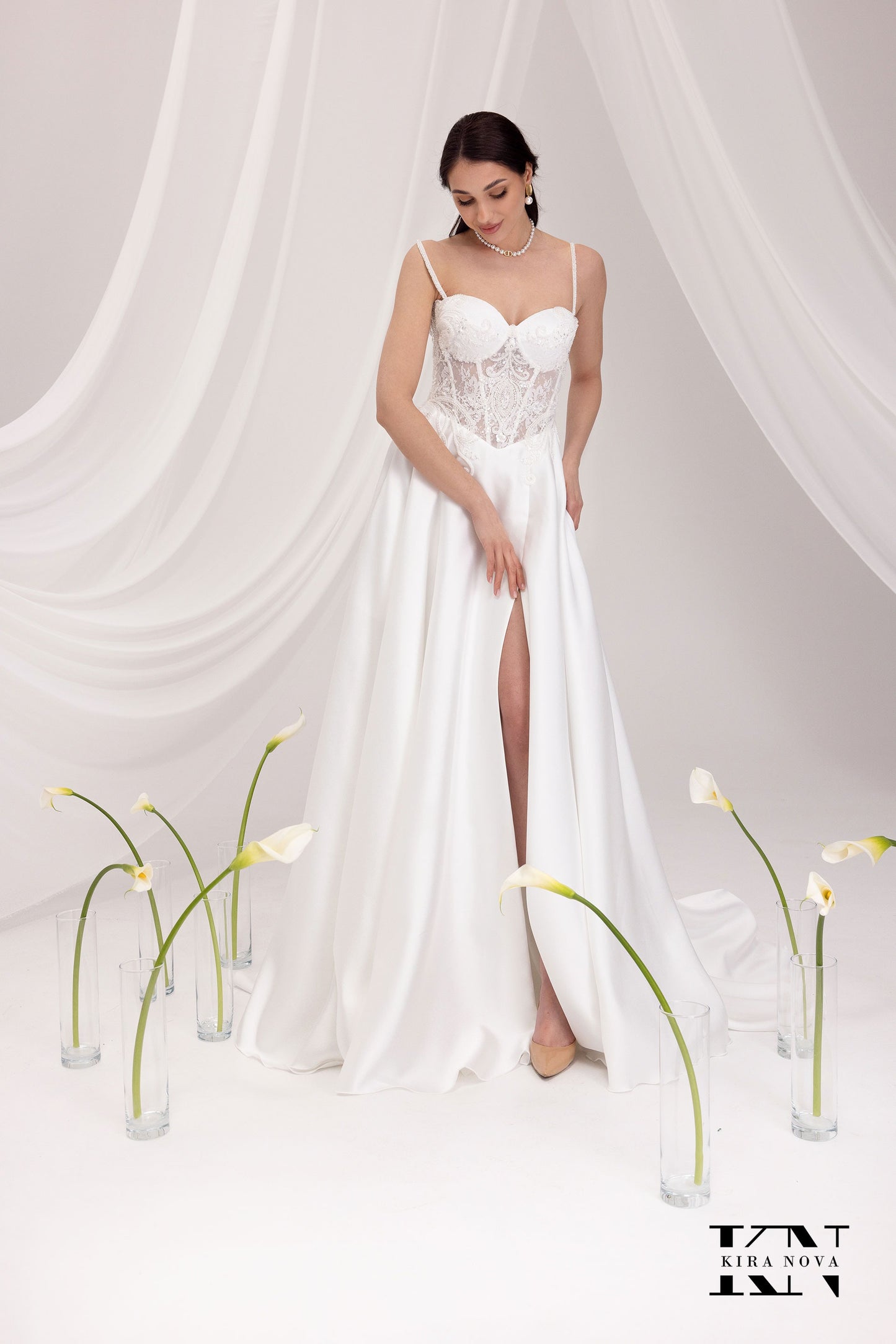 Bride in Kira Nova Judy wedding dress – white lace corset bodice, spaghetti straps, satin A‑line skirt with side slit
