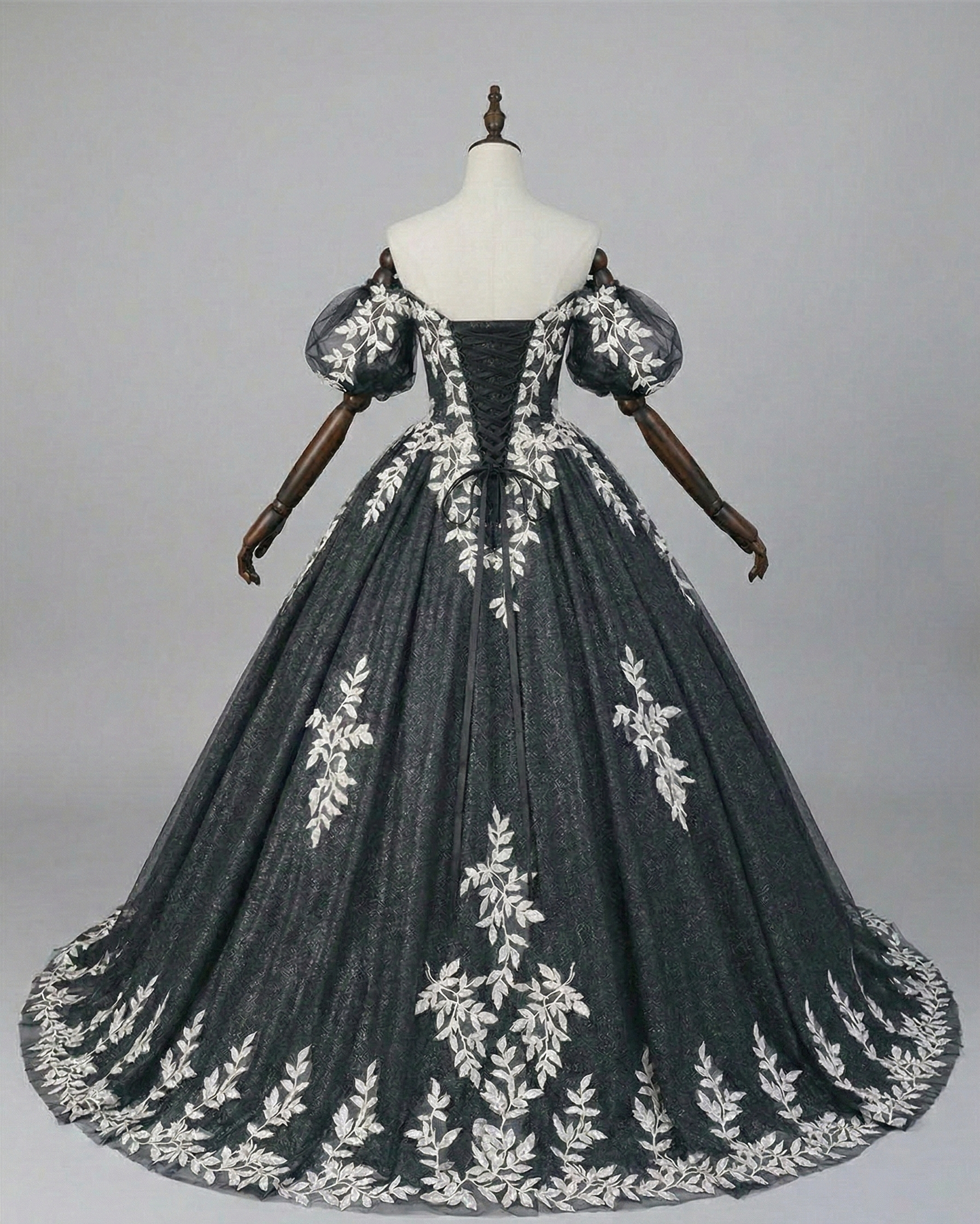 Back view of black corset wedding gown with lace-up detail and cathedral train