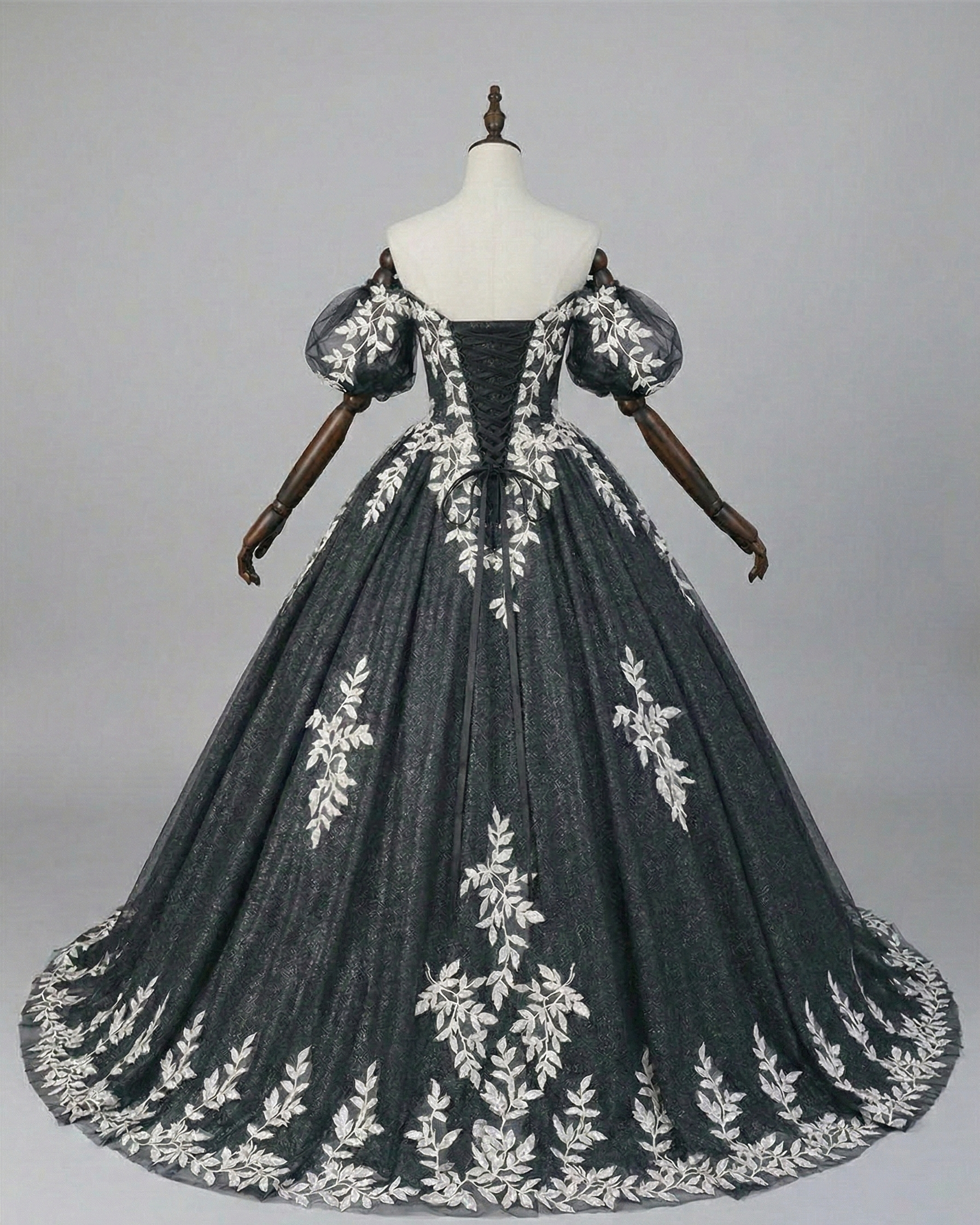 Back view of black corset wedding gown with lace-up detail and cathedral train