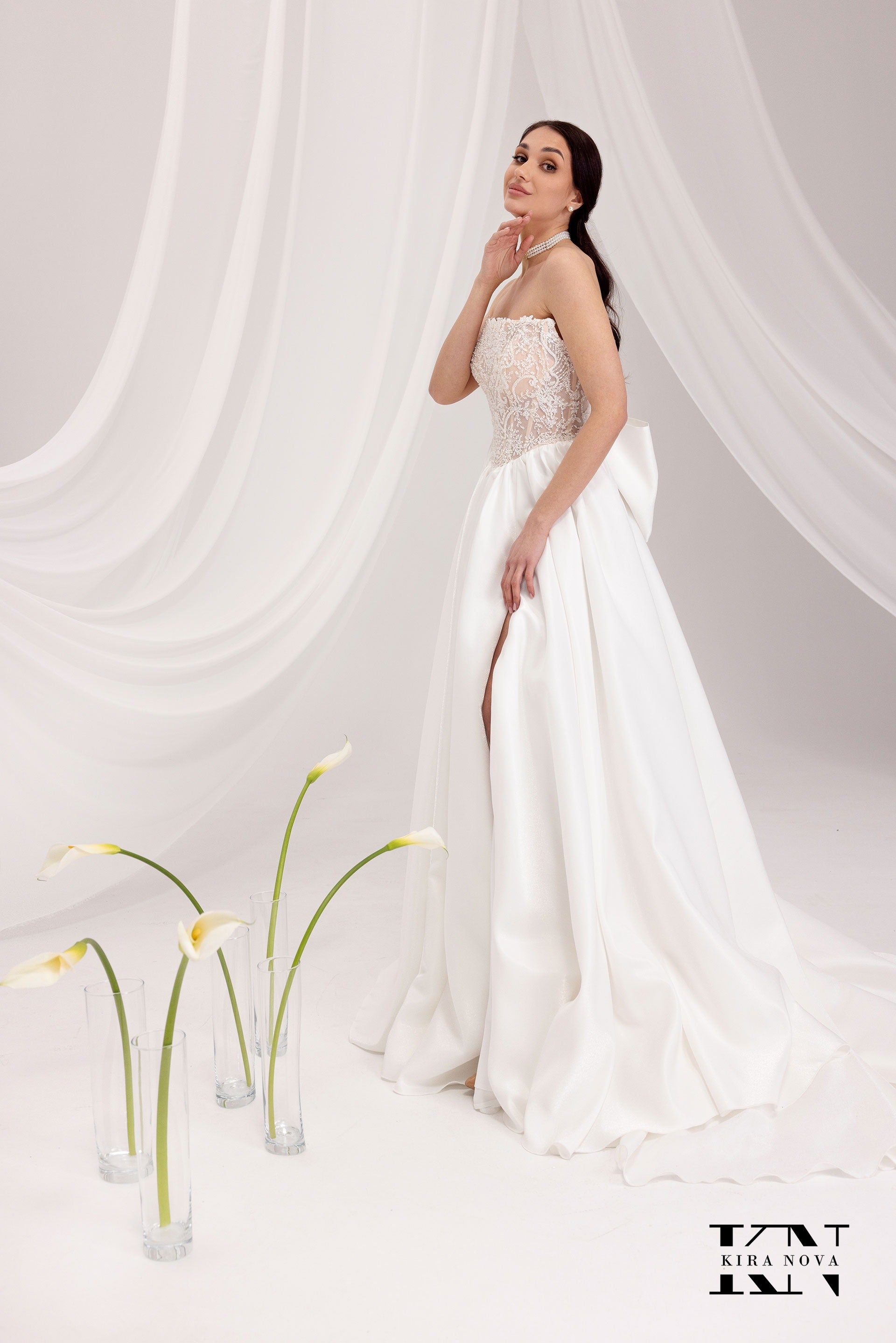 Kira Nova Aspen wedding gown – strapless duchess satin ballgown with dropped waist, draped detail, optional front slit
