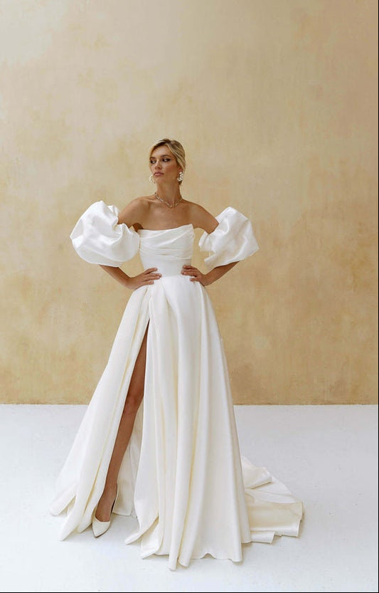 Bride in Mildred wedding dress by Natalia Romanova with off-shoulder puff sleeves and high slit